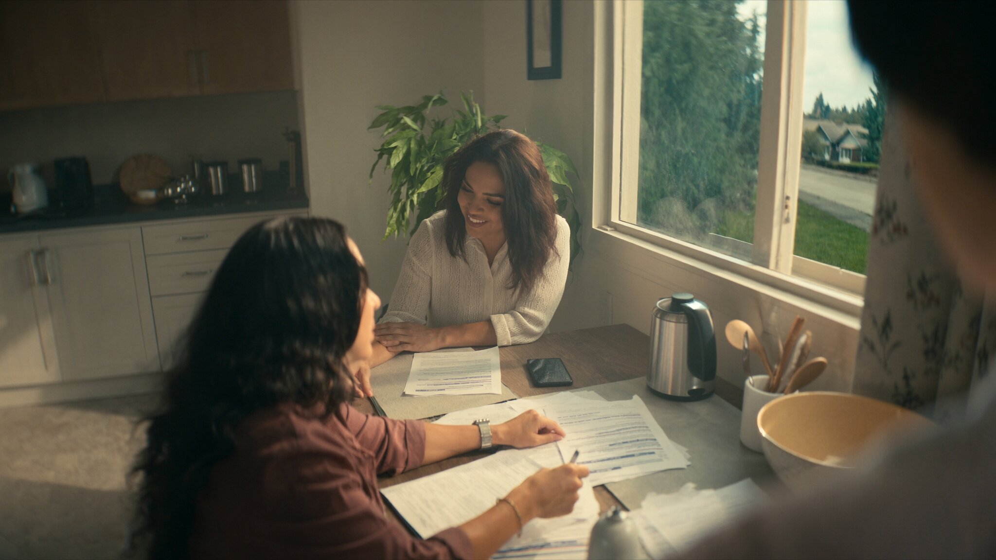 First-time home buyers reviewing FHA vs conventional loan documents at kitchen table in Pacific Northwest home, King County WA