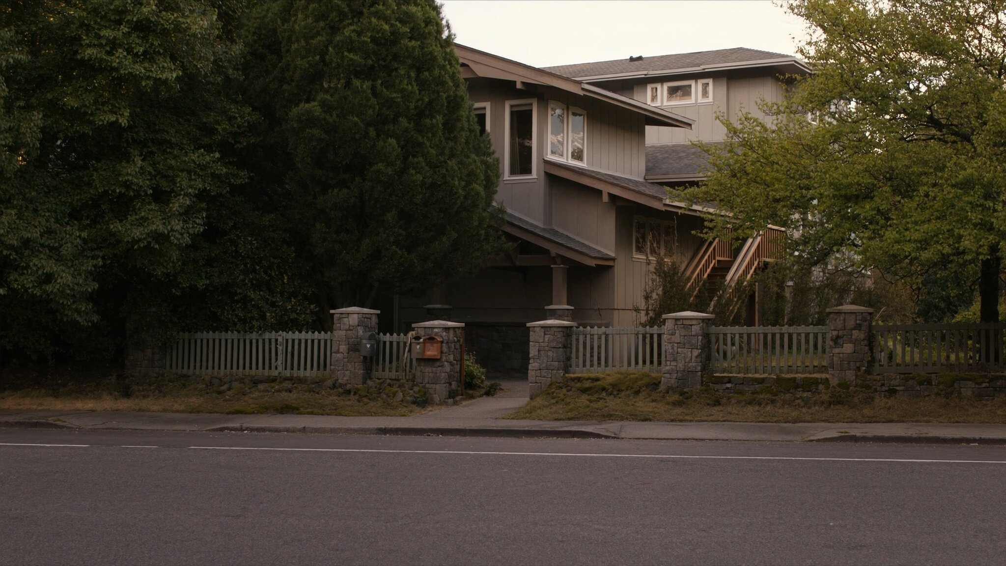 Appraiser with clipboard standing outside a craftsman home in a King County neighborhood, assessing property value for a Washington state home sale