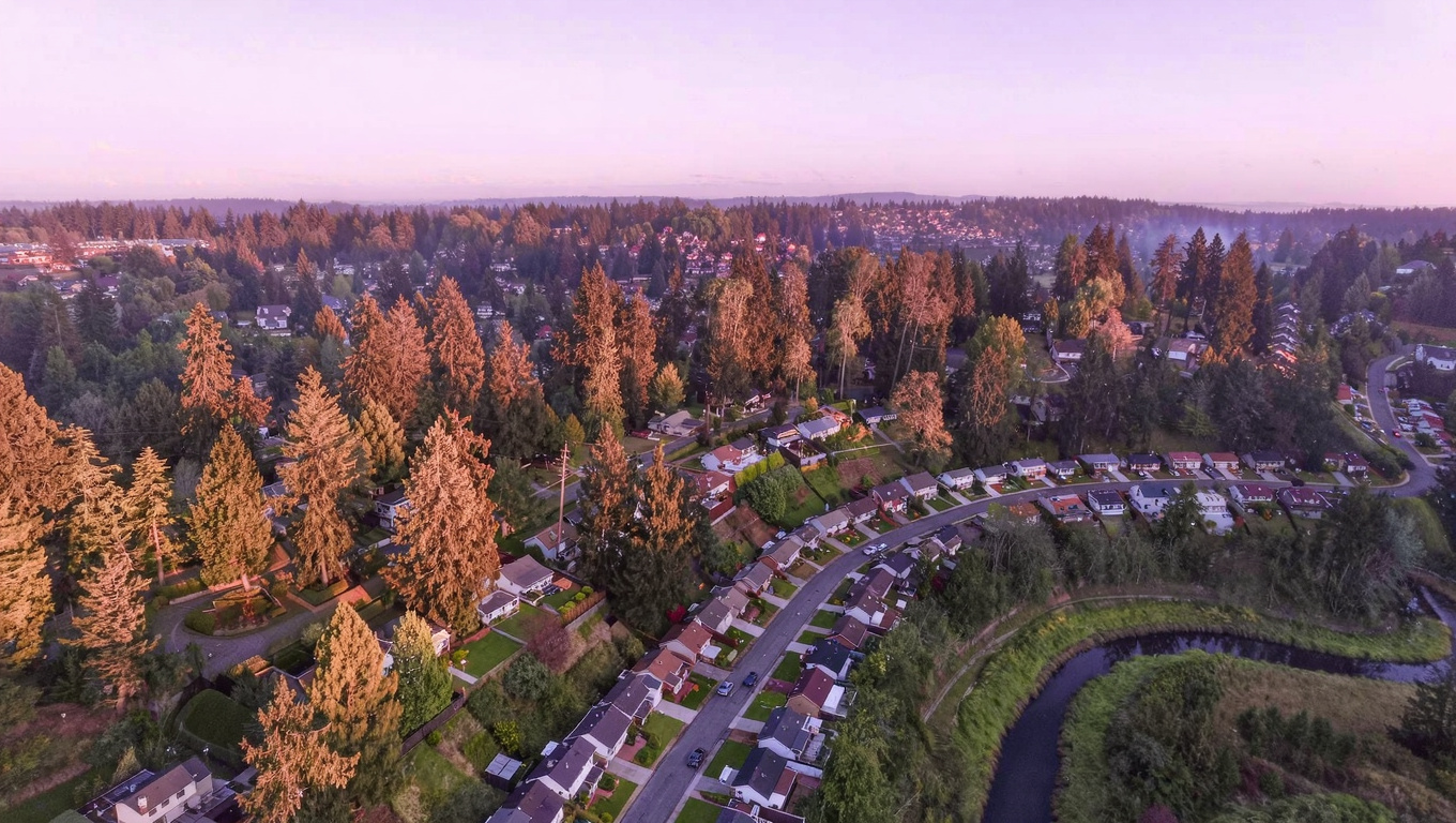 Residential street in East Renton, King County, Washington, with mature Pacific Northwest trees and generous lot setbacks.