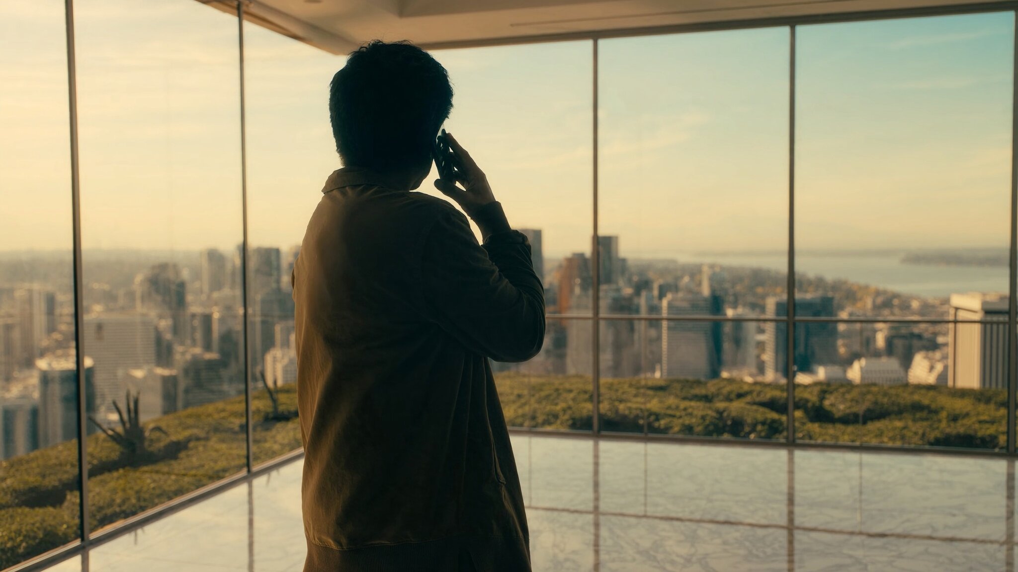 Renter looking out at the Bellevue WA skyline from a modern apartment window, contemplating the rent vs. buy decision in 2026