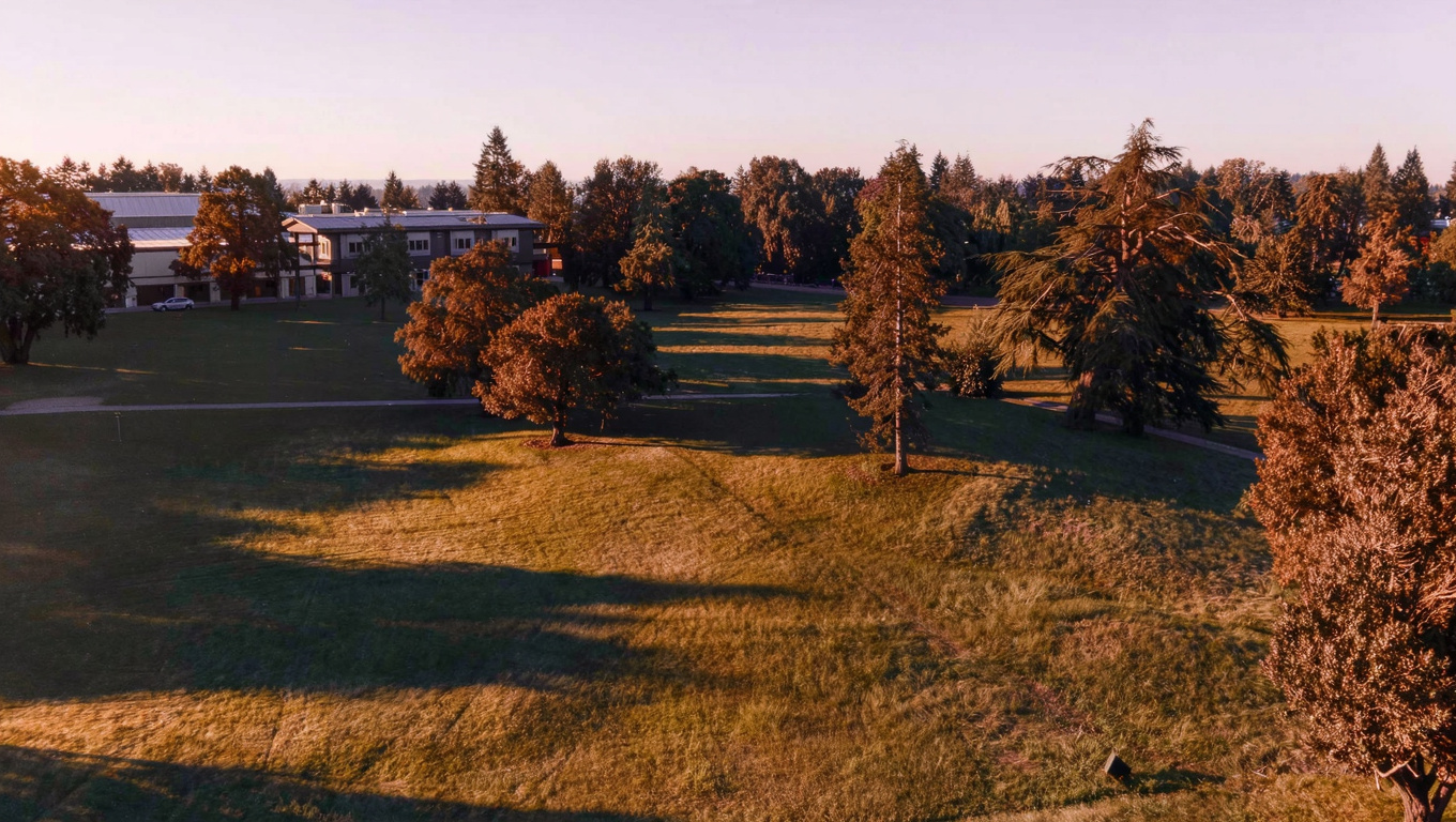 Highlands Neighborhood Park in Renton Washington with open grass fields, mature trees, and community center building.