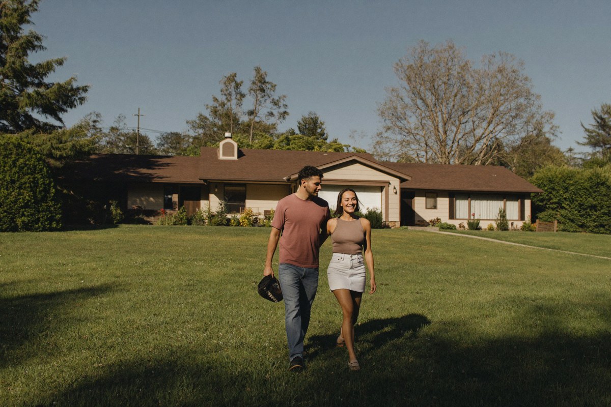 Young couple touring a single-family home in Kent or Auburn, South King County, in summer light