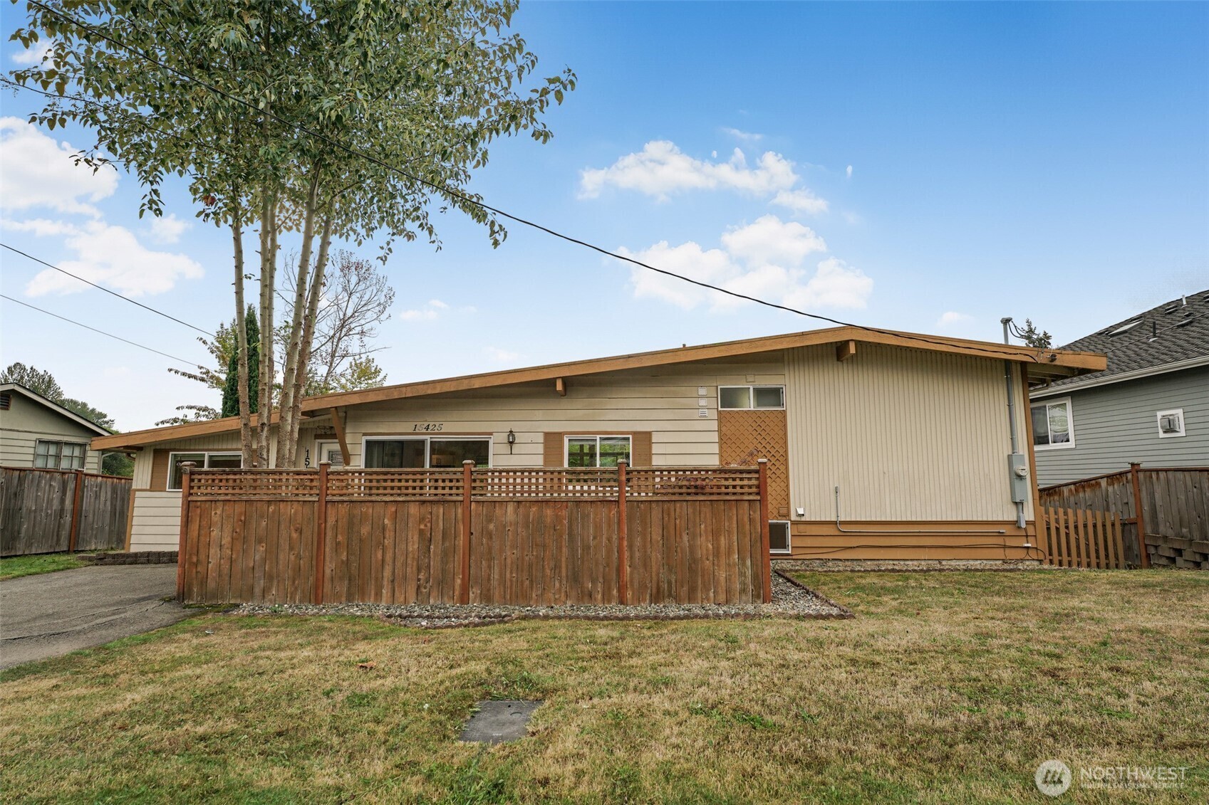 Front of the home with cedar fence and lawn