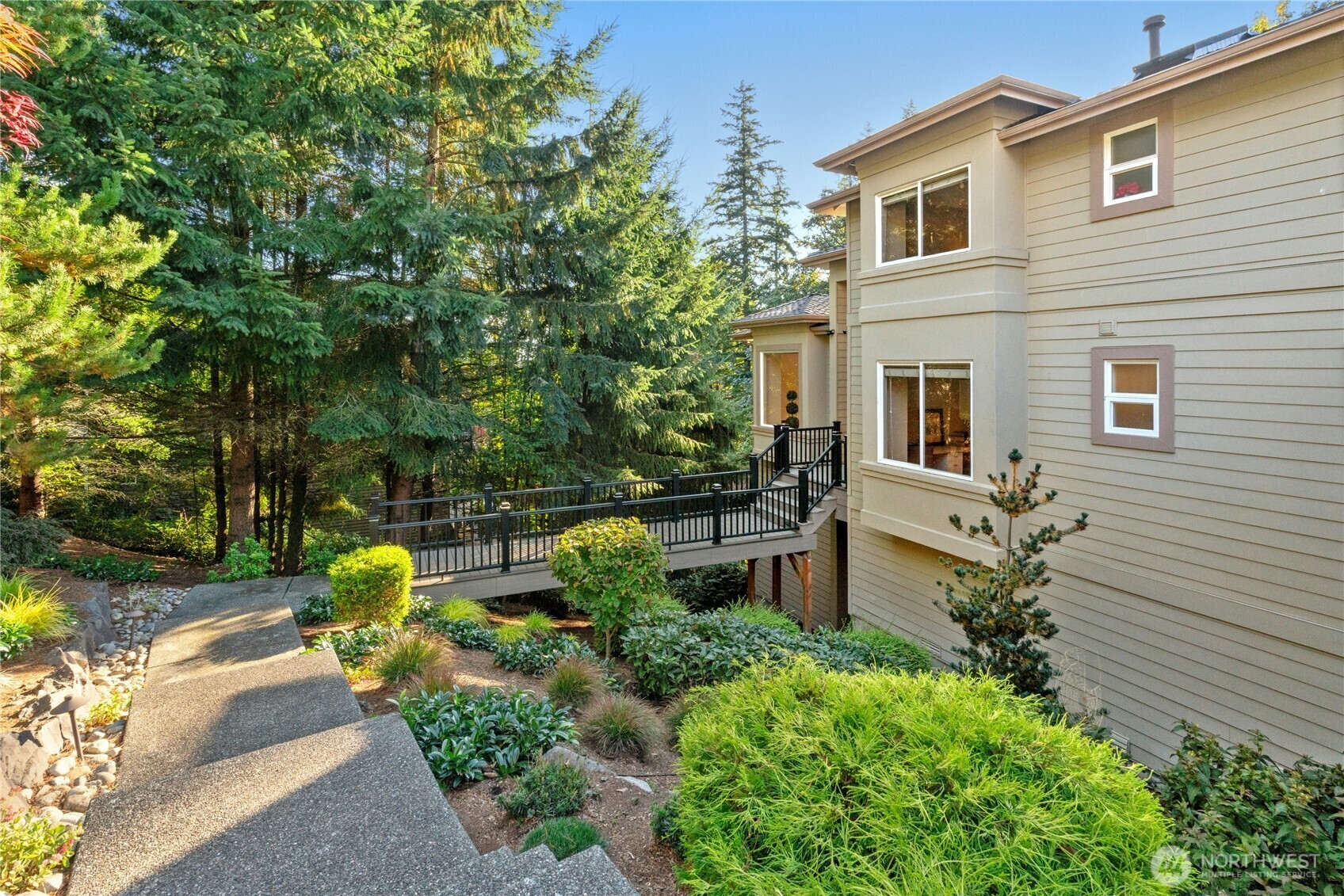 Side of the home with terraced landscaping and the deck