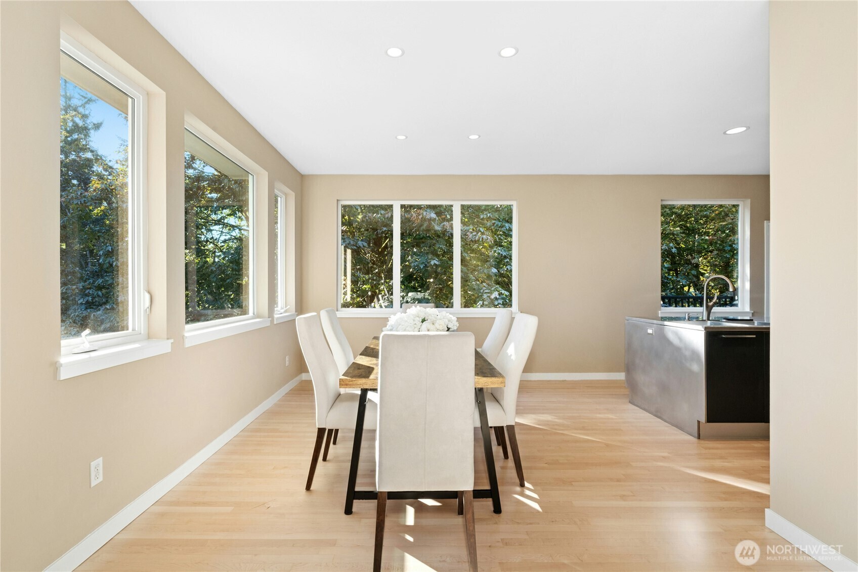 Dining room with tall windows facing the trees