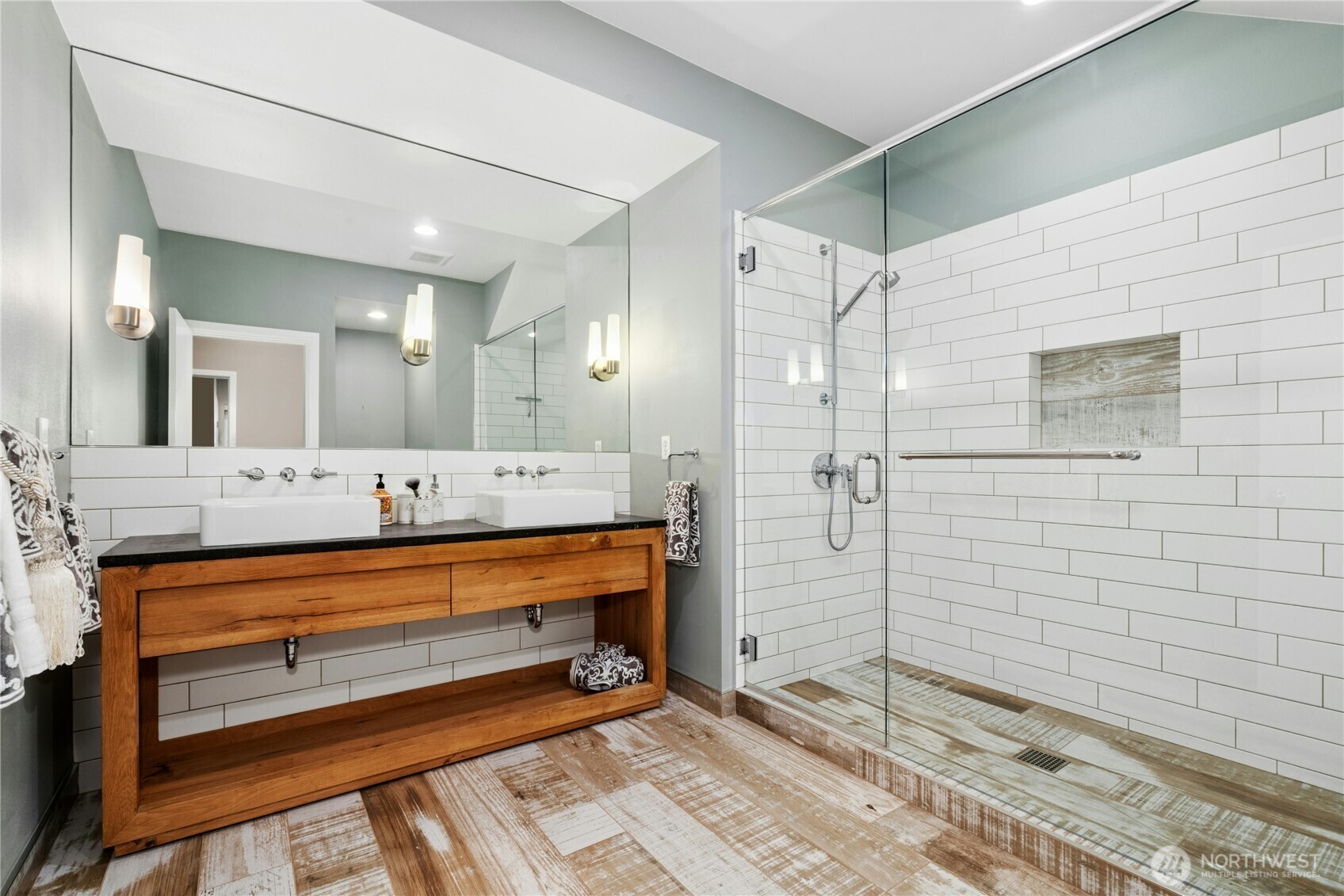 Remodeled lower-level bath with large walk-in shower and double sinks